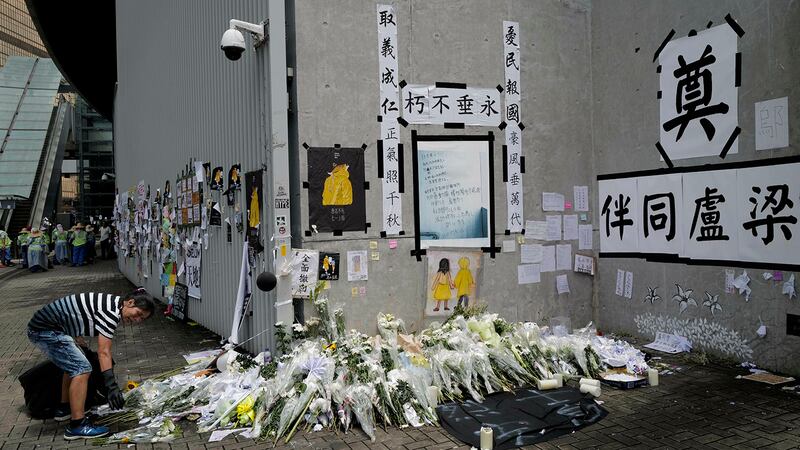 一名女子在清理香港立法会大楼外的一个场地。(美联社)